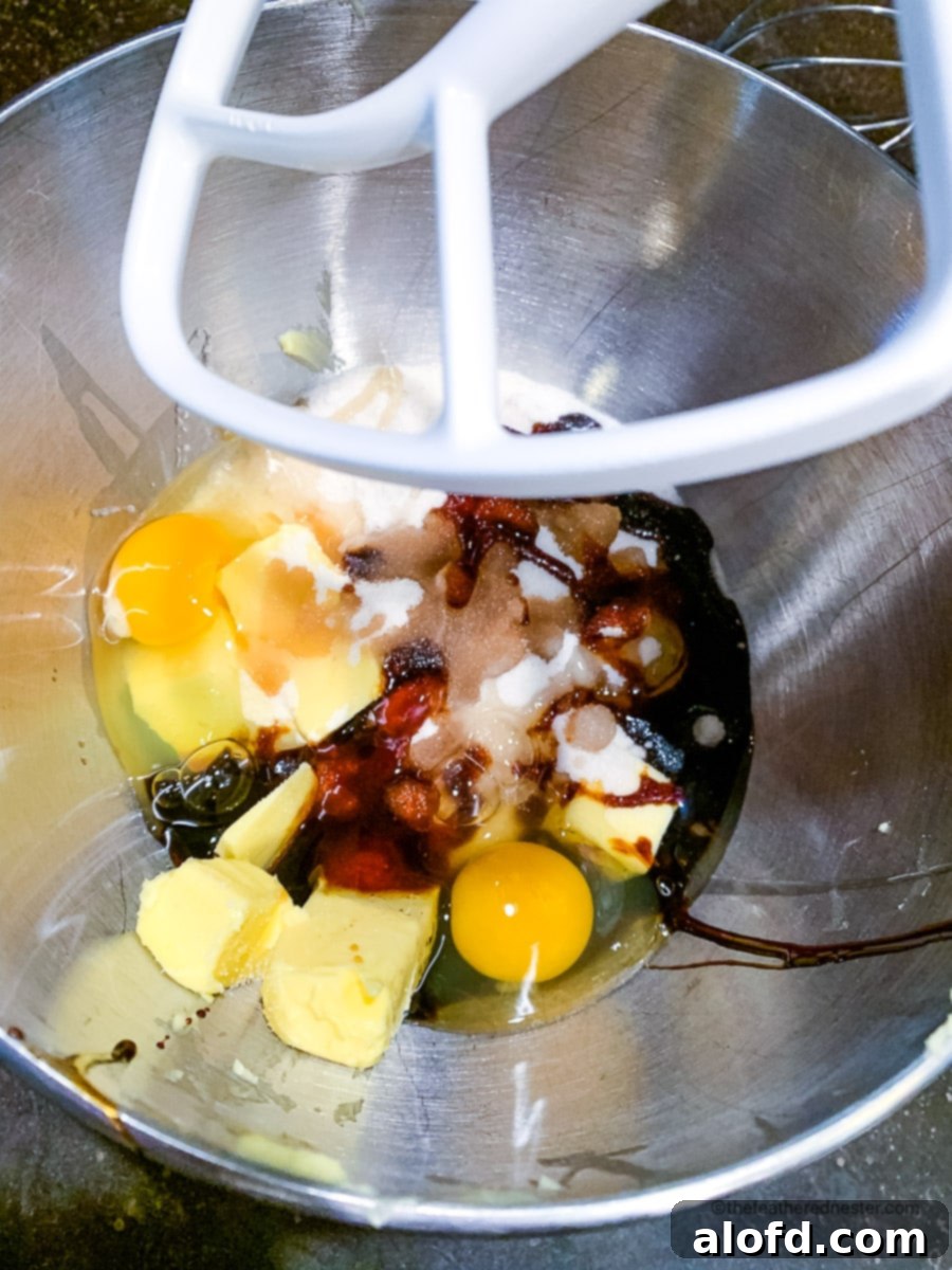 Wet ingredients (butter, sugar, eggs) creamy and combined in a stand mixer bowl, ready for dry ingredients.