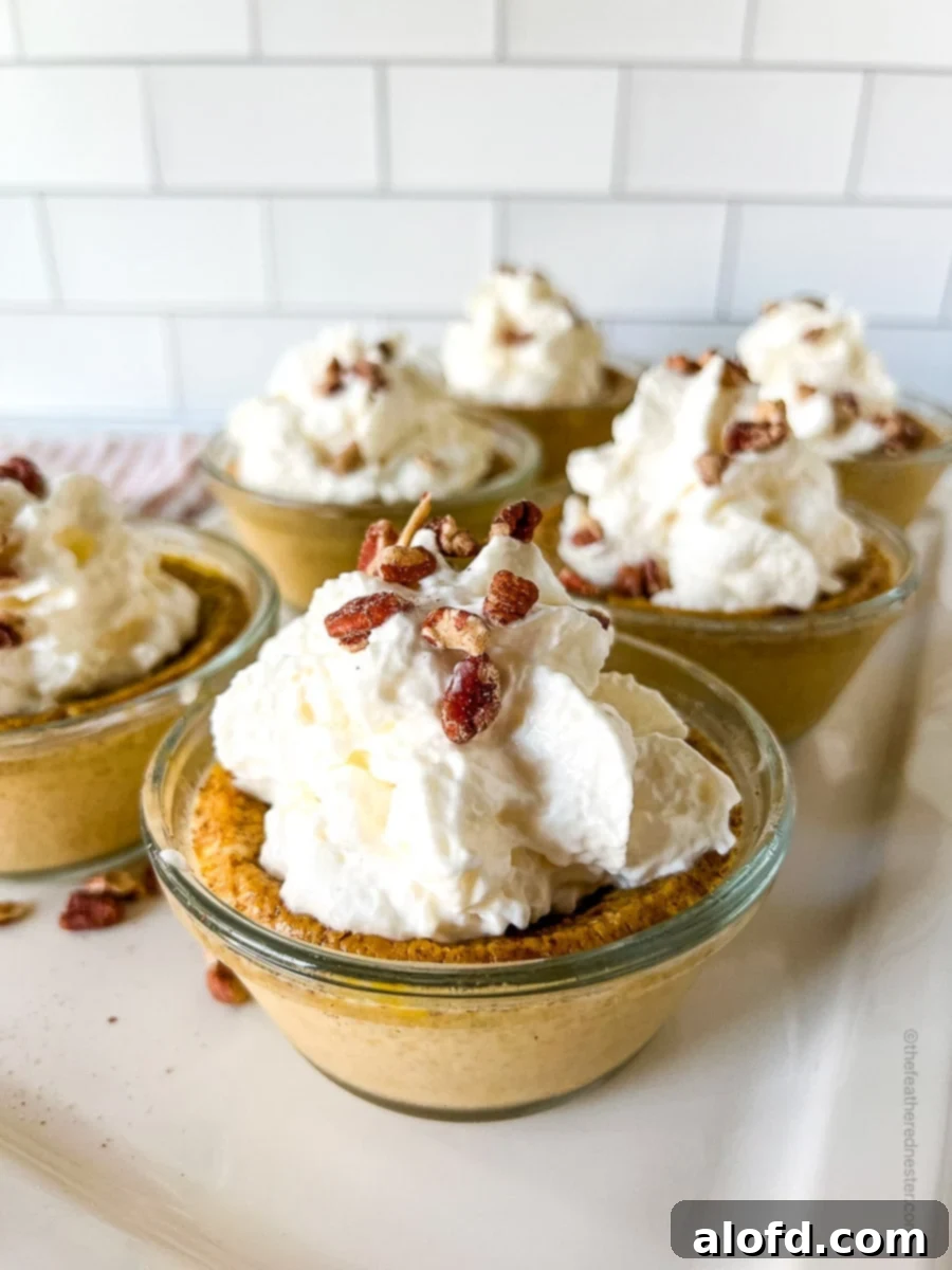 Six individual cups of creamy pumpkin custard, generously topped with whipped cream and a sprinkle of chopped nuts.
