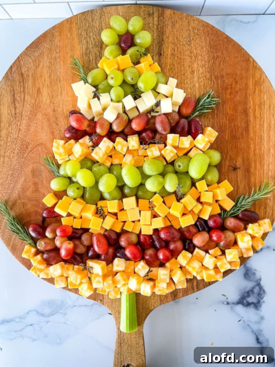 Whimsical Christmas Tree Fruit and Cheese Display 2 Christmas Tree Cheese Appetizer on a wooden board.