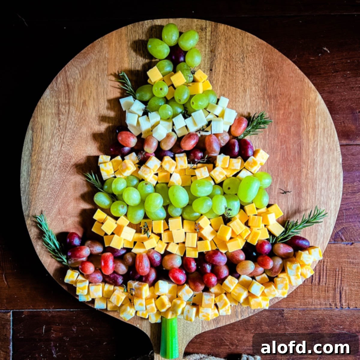 Whimsical Christmas Tree Fruit and Cheese Display 5 Christmas Tree Cheese Appetizer on a wooden board with a dark background.