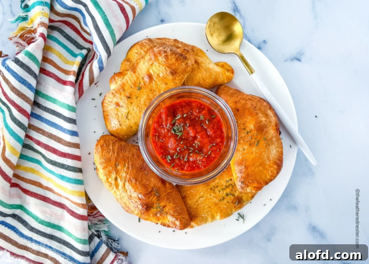 Savory Pepperoni Calzone Pockets 15 A beautiful platter showcasing mini pepperoni calzones alongside a dipping bowl of marinara sauce, perfect for serving.