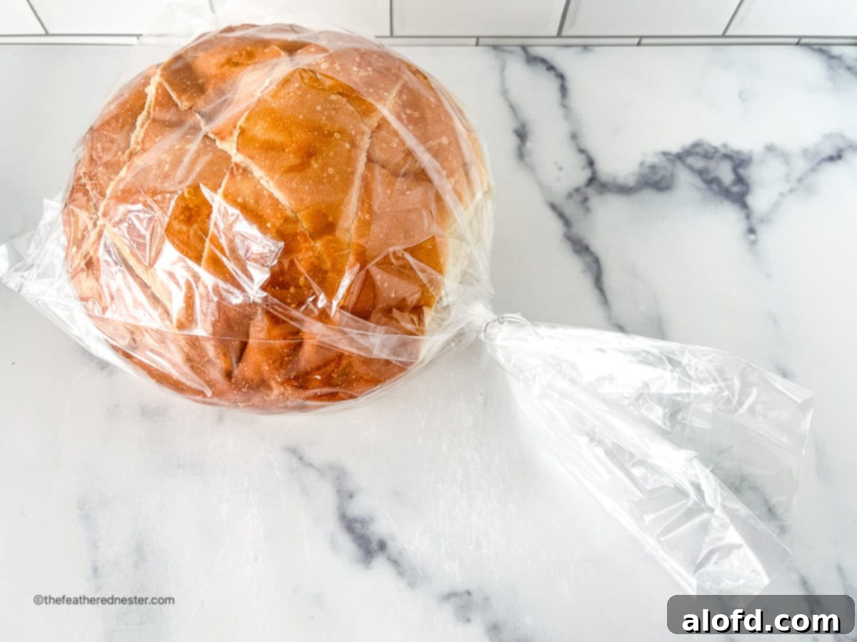 Round loaf of sourdough bread stored in a plastic bag.
