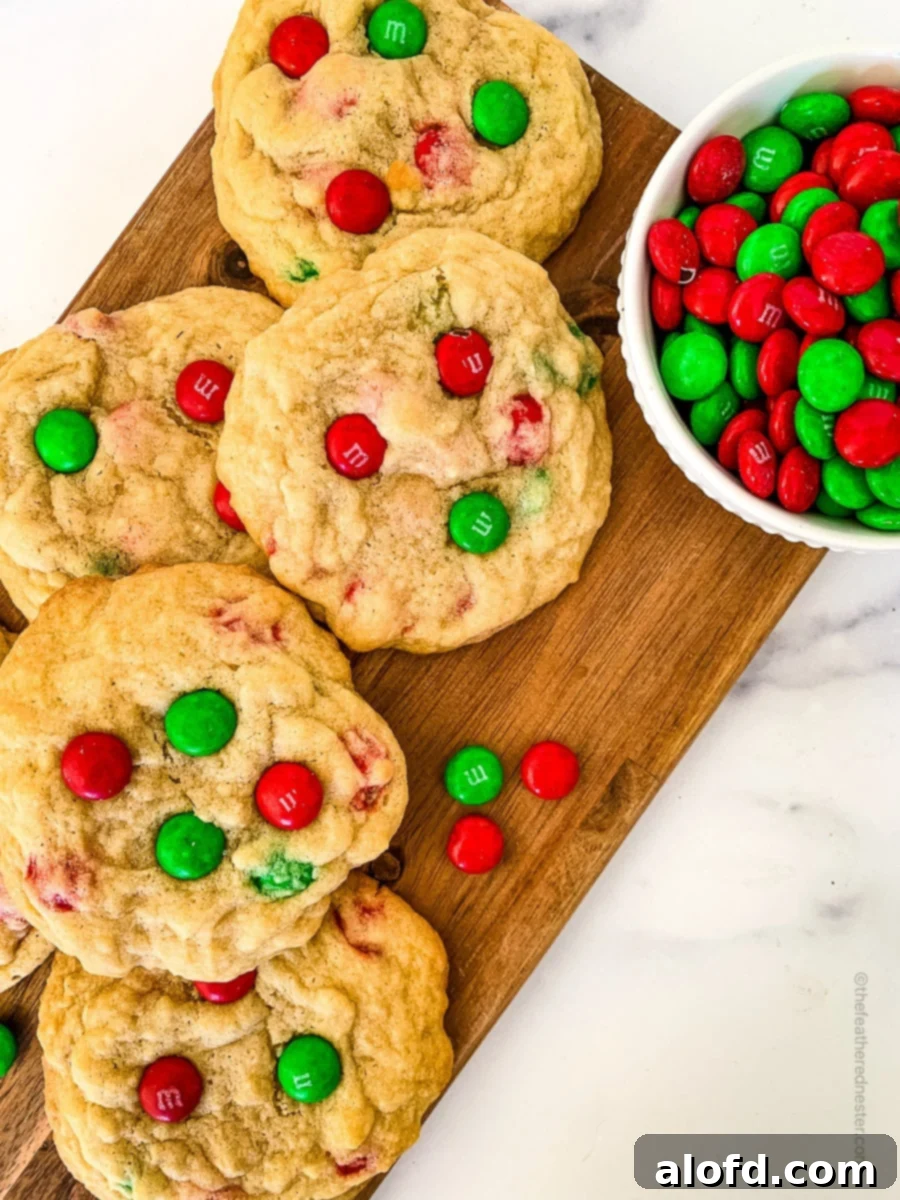 Festive M and M Christmas Cookies 2 Christmas M&M Cookies on a wooden board and a small bowl with M&Ms on it.