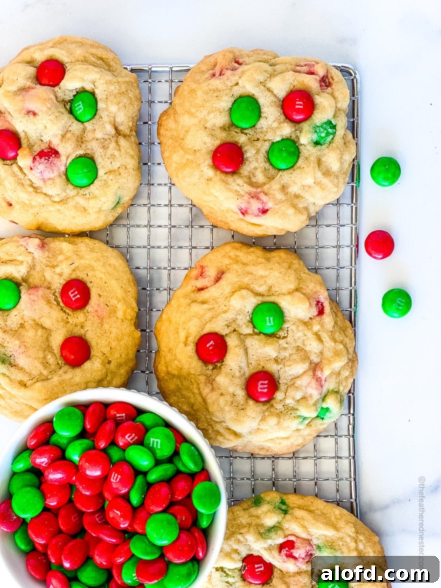 Festive M and M Christmas Cookies 8 Christmas M and M cookies on a cooling rack with a small bowl full of M&M's.