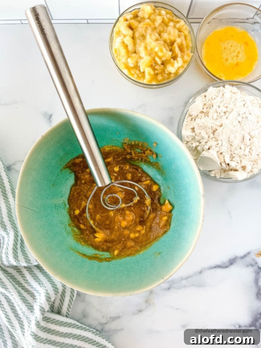 Creamed butter, brown sugar, and vanilla extract in a green mixing bowl, ready for the next ingredients.