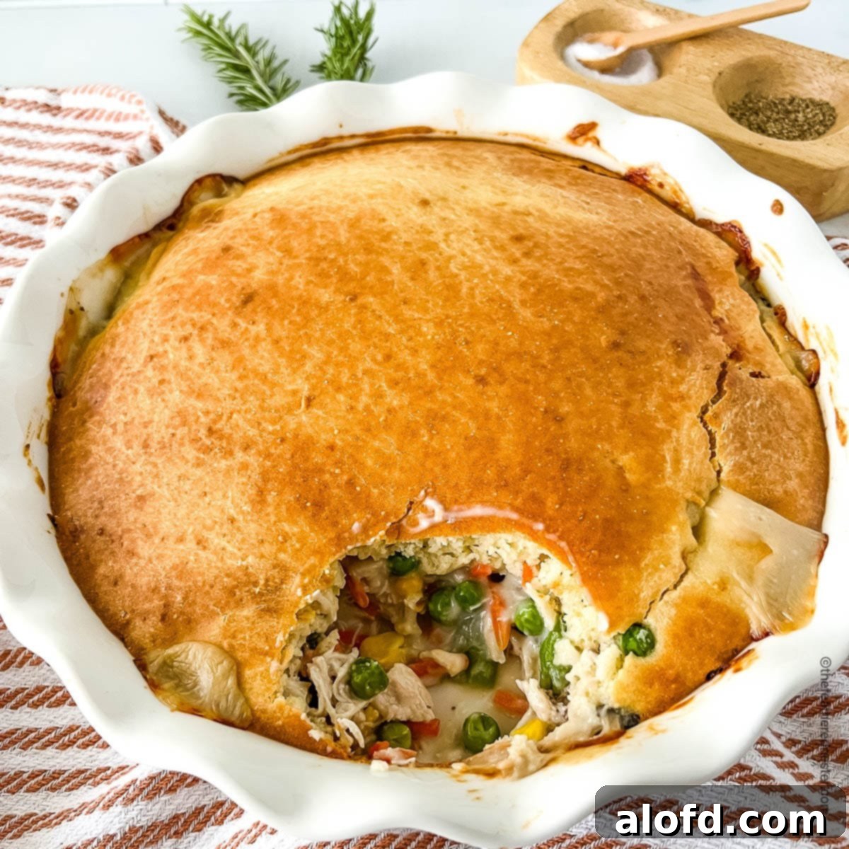 Easy Bisquick Chicken Pot Pie Bake 7 peas, carrots, corn, and shredded chicken peeking through a flaky crust