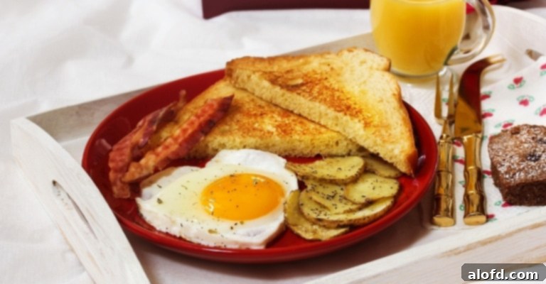 A romantic breakfast in bed setup for Valentine's Day, featuring a perfectly fried egg shaped like a heart, nestled among other delicious breakfast items, on a charming serving tray.