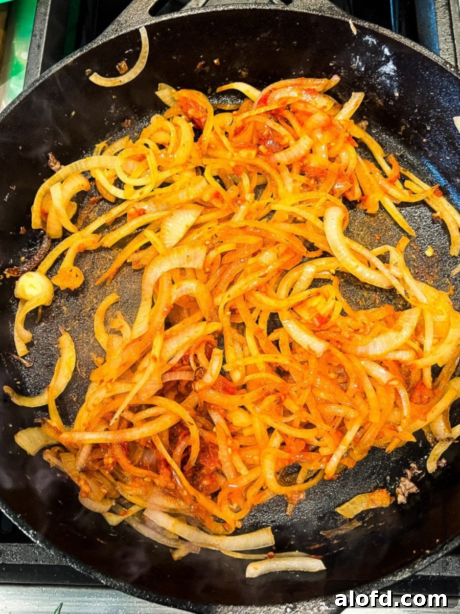 Tender Slow Cooker Swiss Steak 6 browned onions on a skillet.
