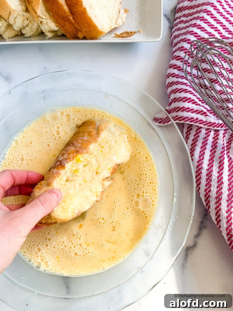 Luscious Strawberry French Toast 7 Dipping a thick slice of bread into a shallow bowl of French toast batter.