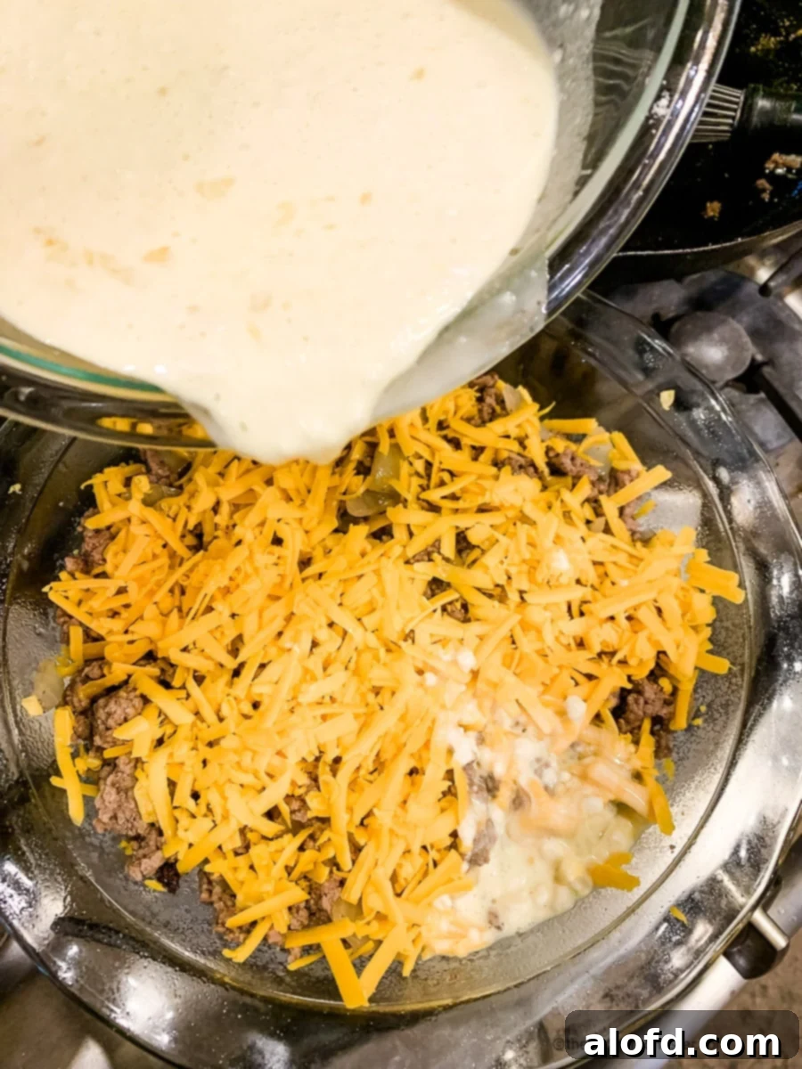 Hearty Bisquick Cheeseburger Bake 7 Pouring white batter into a baking dish for cheesy hamburger pie.