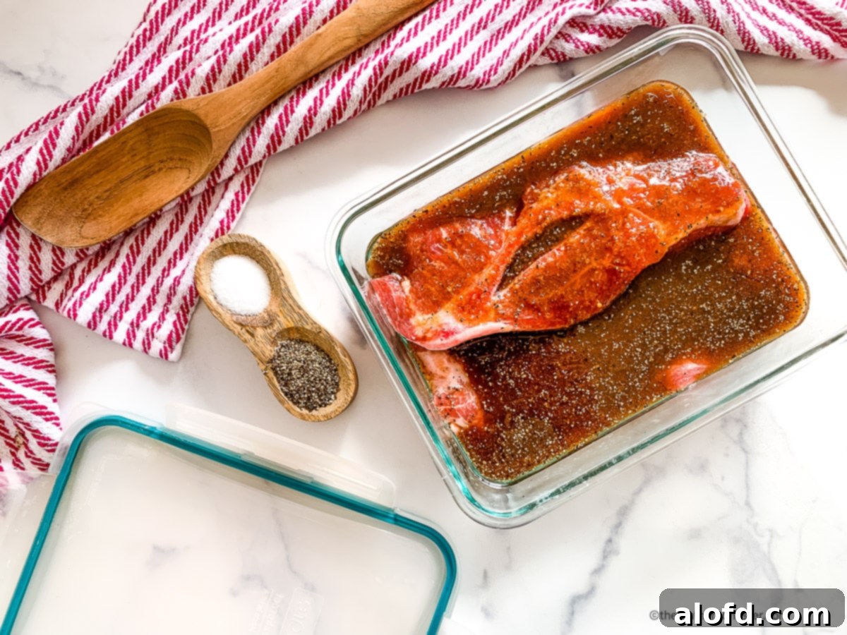 Raw pork steaks in a glass dish of Asian pork chop marinade, ready for cooking.