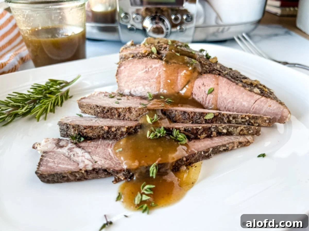 Fall-Apart Slow Cooker Sirloin Tip Roast 3 Crock pot sirloin tip roast slices on a white plate.