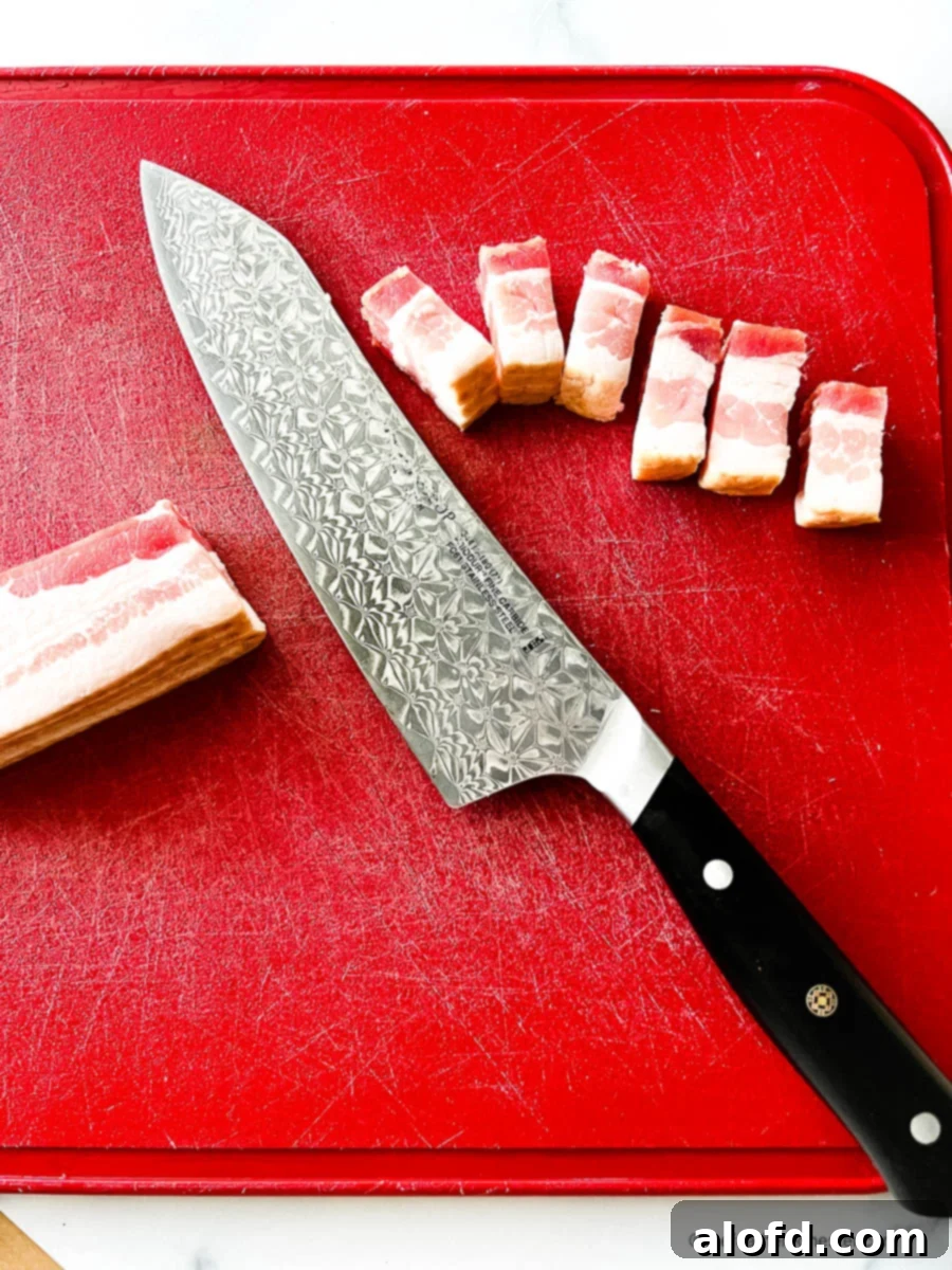 Thick cut bacon and a Chef's knife on a red cutting board
