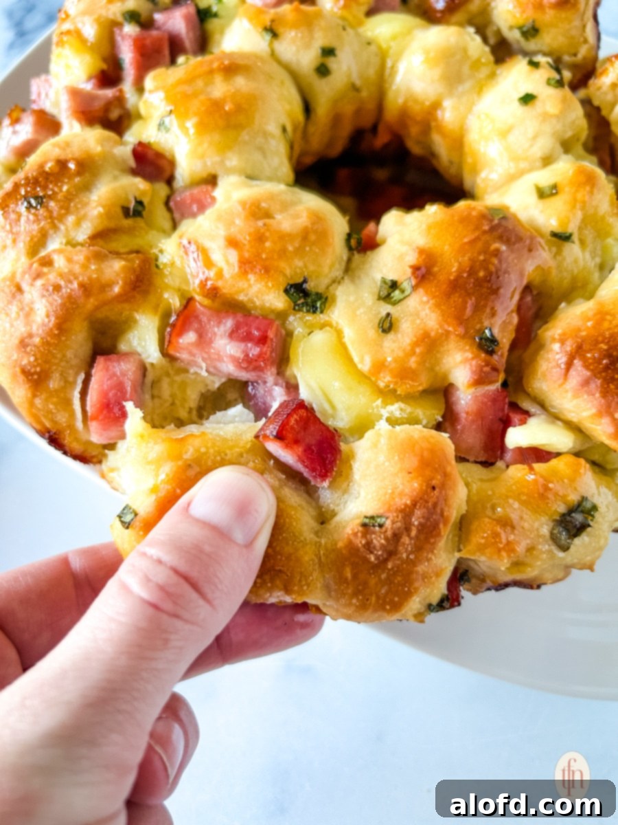 Pulling a part of monkey bread with ham and brie.