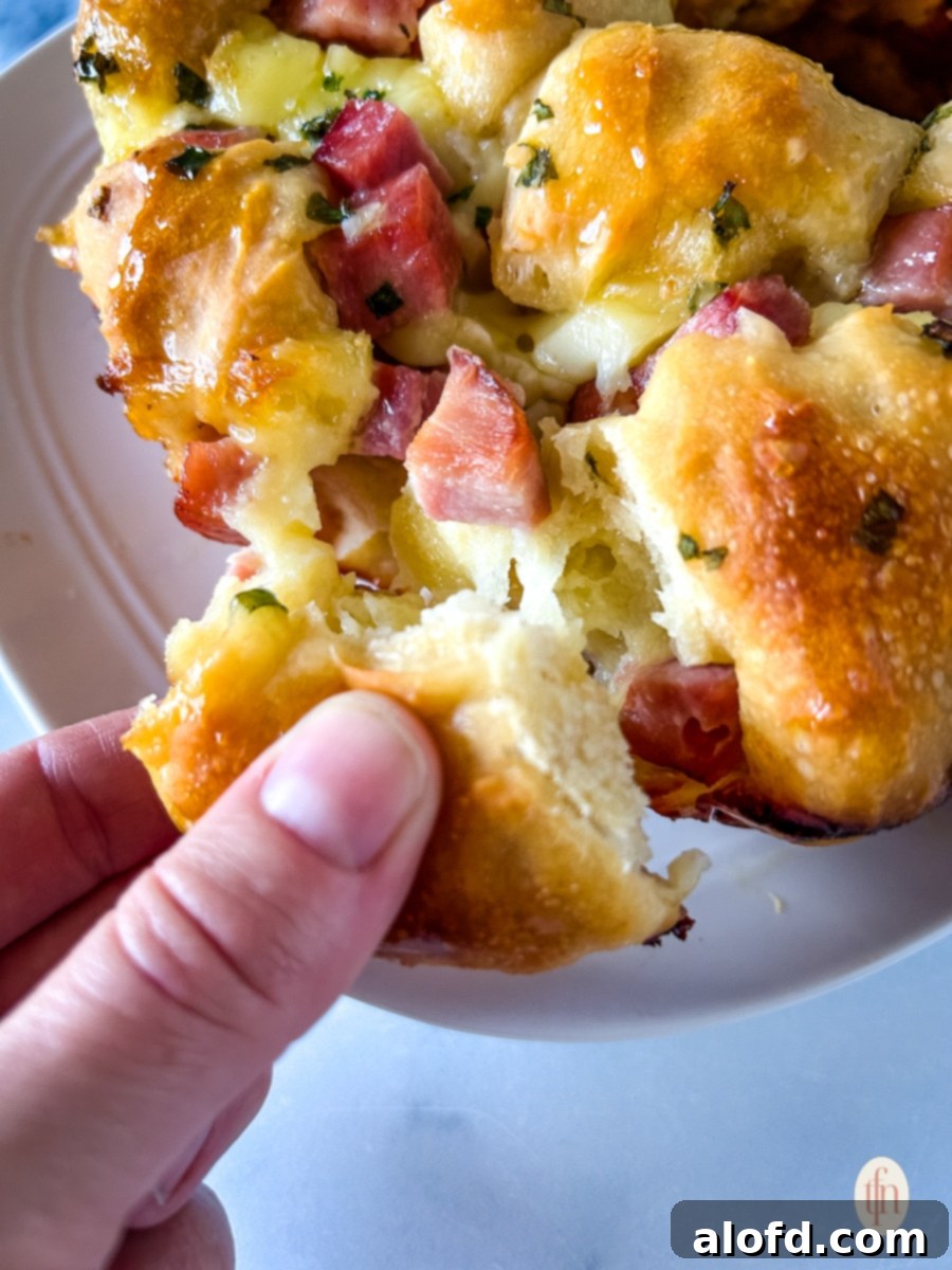 Pulling a part of monkey bread with ham and brie.