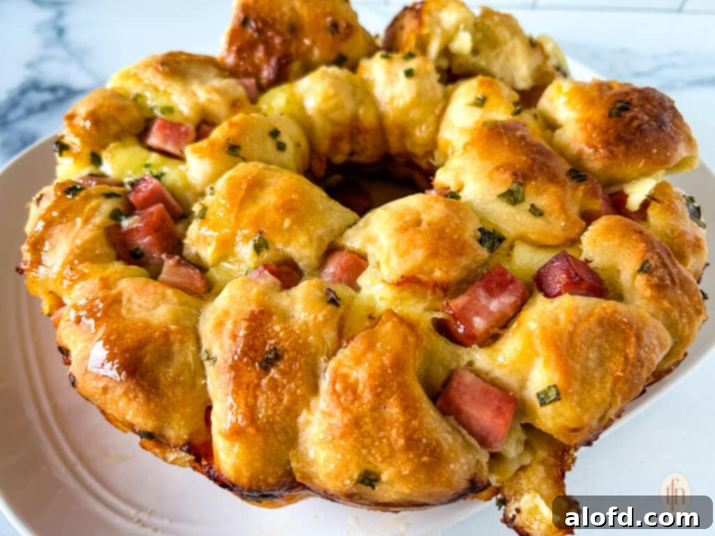 Horizontal image of monkey bread with ham and brie on a white plate.