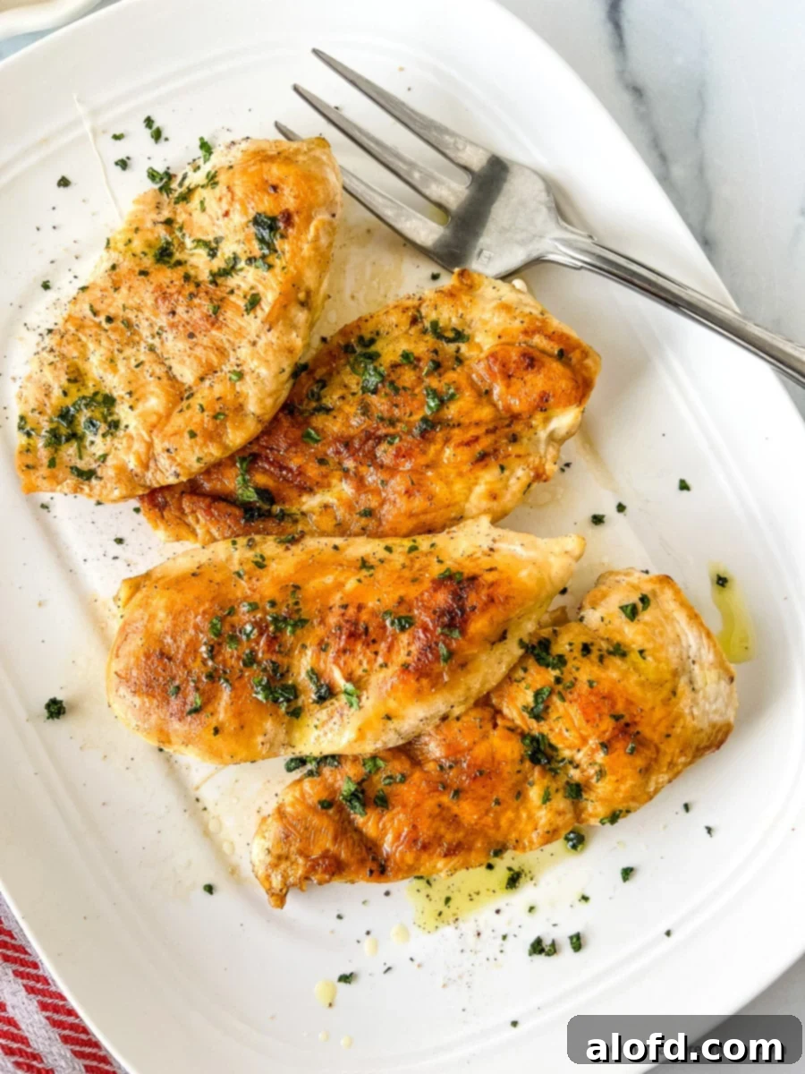 Perfectly Seared Cast Iron Chicken Breast 2 Perfectly seared boneless skinless chicken breast on a serving plate with a fork.