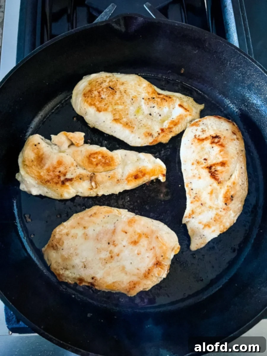 Perfectly Seared Cast Iron Chicken Breast 8 Seared boneless skinless chicken in skillet.