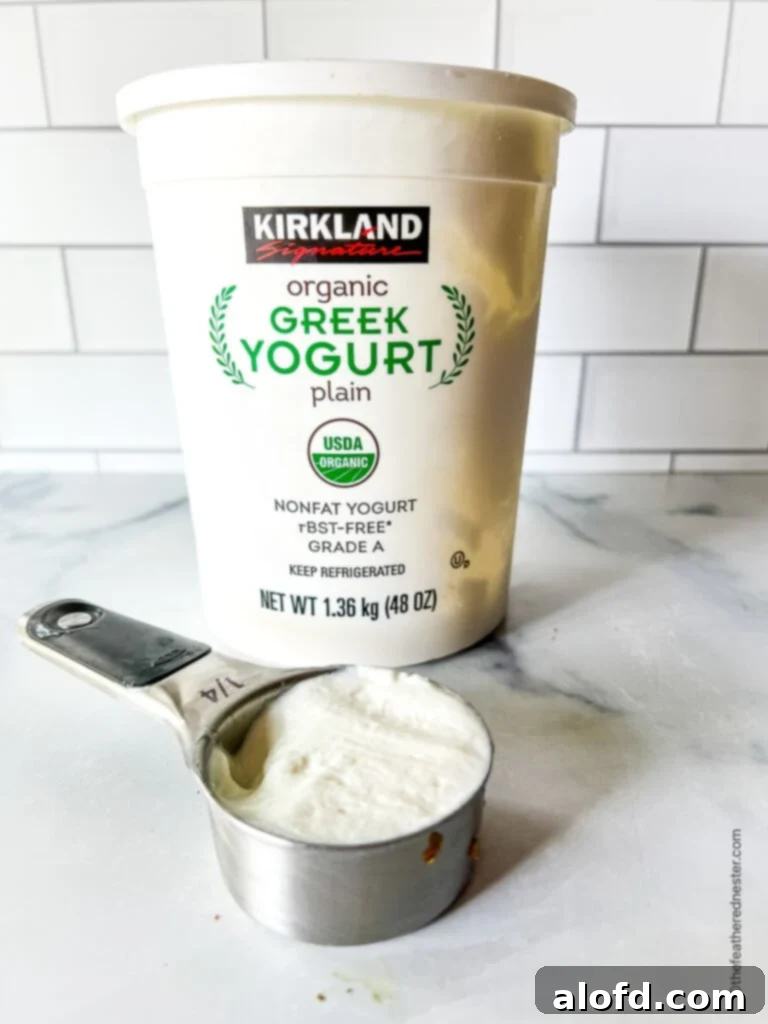 8 Simple Swaps for Egg-Free Cornbread 9 Measuring cup of Greek yogurt, with yogurt container behind it.