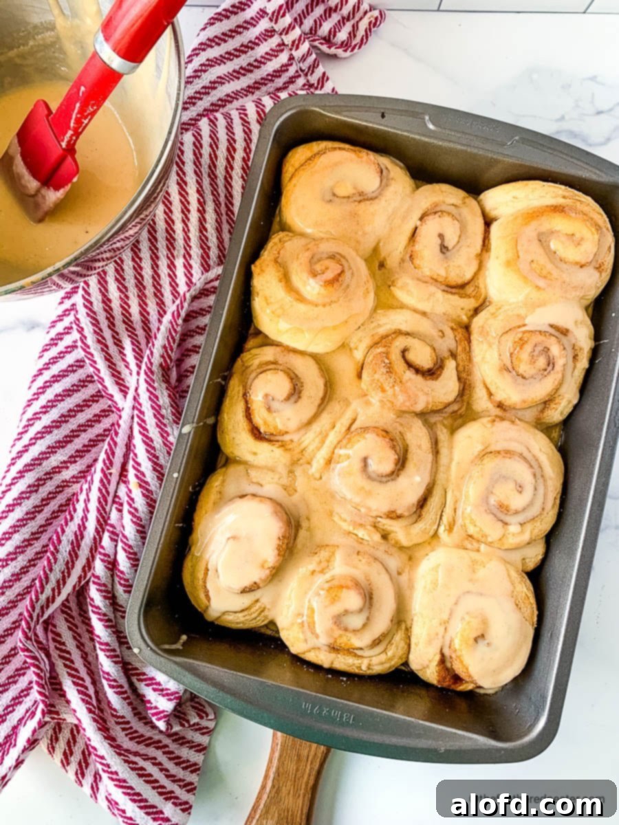 Fluffy Sourdough Discard Cinnamon Rolls 2 A golden pan of freshly baked and glazed sourdough discard cinnamon rolls, ready to be enjoyed.