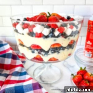 A beautifully layered 4th of July salad in a clear trifle bowl, showcasing the patriotic red, white, and blue colors.