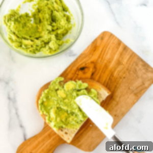 Velvet Avocado Spread 12 Using a spatula to spread creamy avocado on a slice of toast.