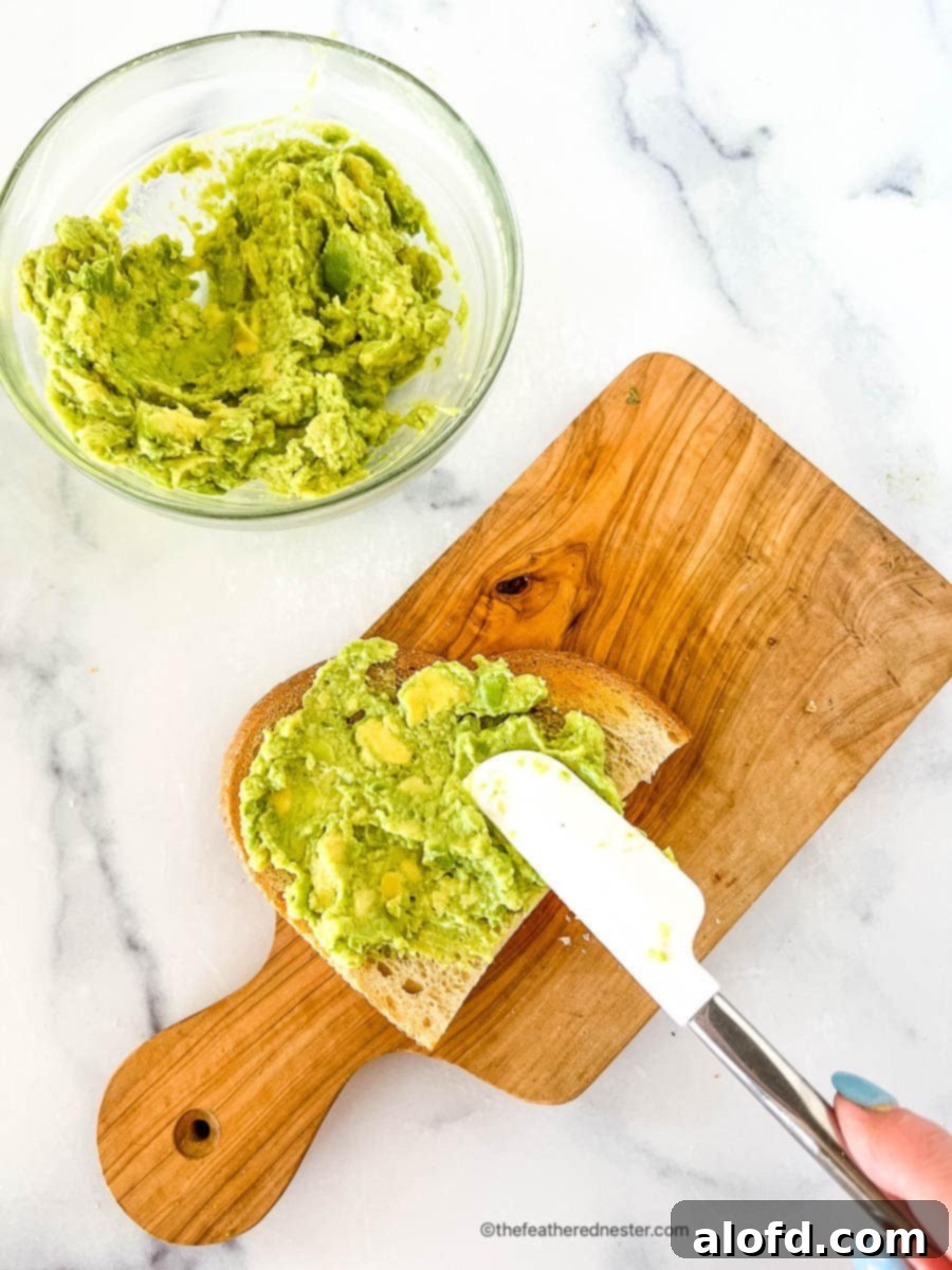 Velvet Avocado Spread 5 Creamy avocado spread being applied to a piece of toast.