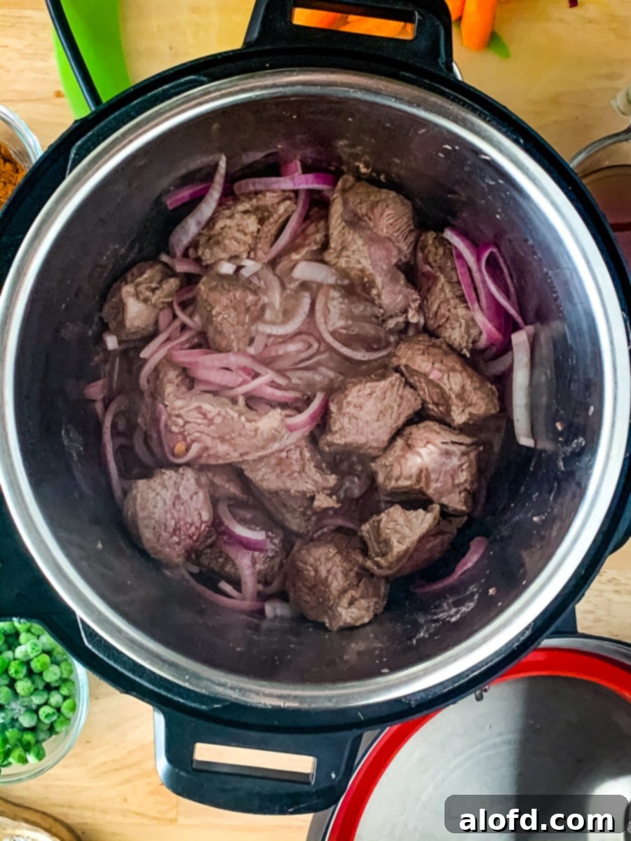 Speedy Savory Beef Stew 4 Close-up of beef and vegetables being sautéed in an Instant Pot, a crucial step for building flavor in this easy beef stew recipe.