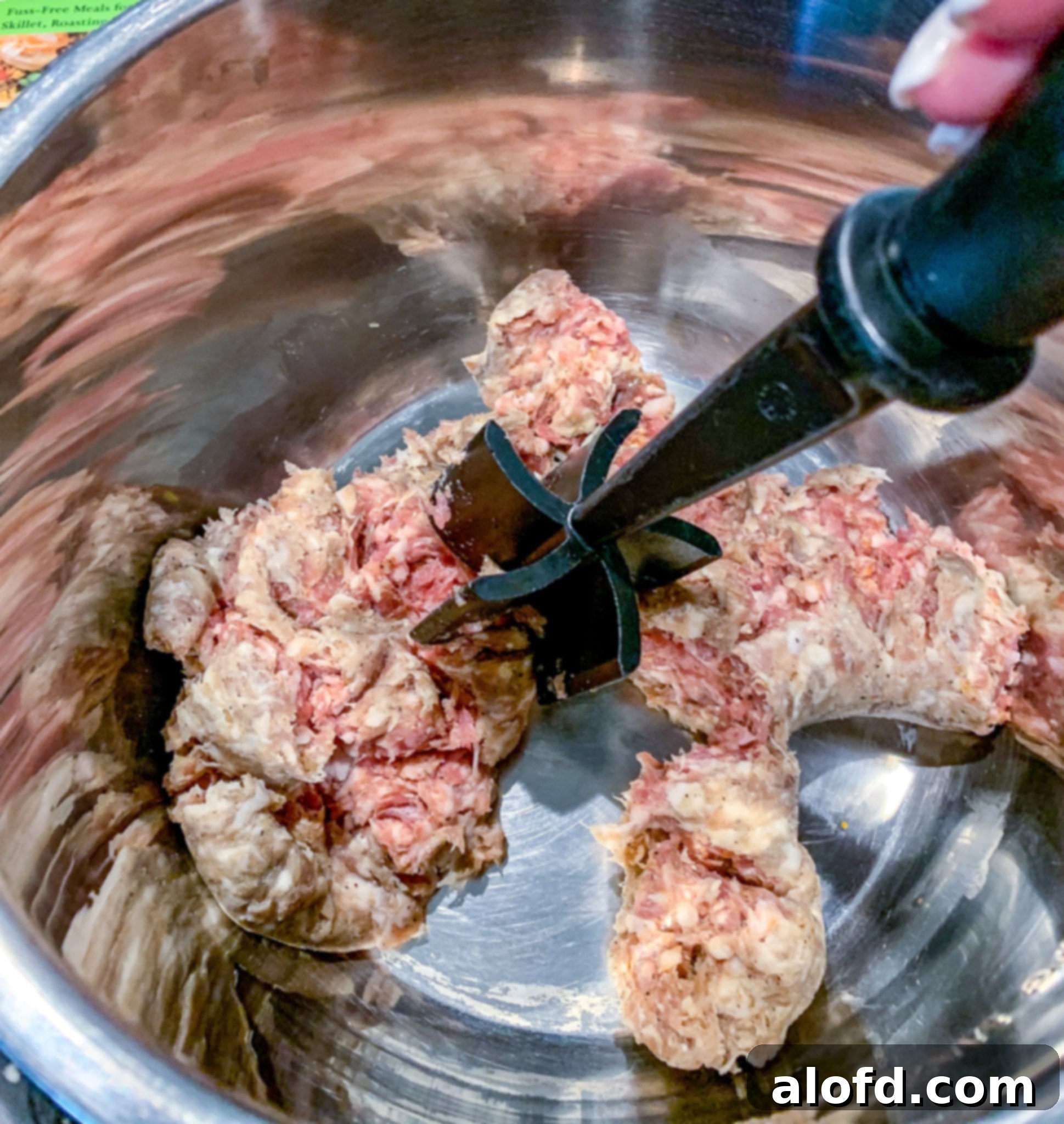 Hearty Instant Pot Lasagna Soup 5 Sausage being sautéed in the Instant Pot with a Pampered Chef Mix N Chop tool to break up the meat.
