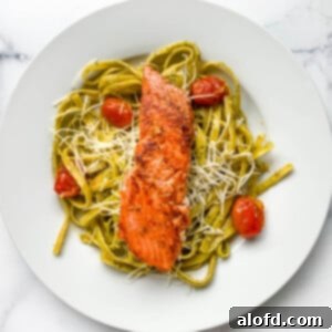 Bright Salmon Pesto Pasta 10 Plated dinner of pesto pasta with a salmon fillet, ready to serve.