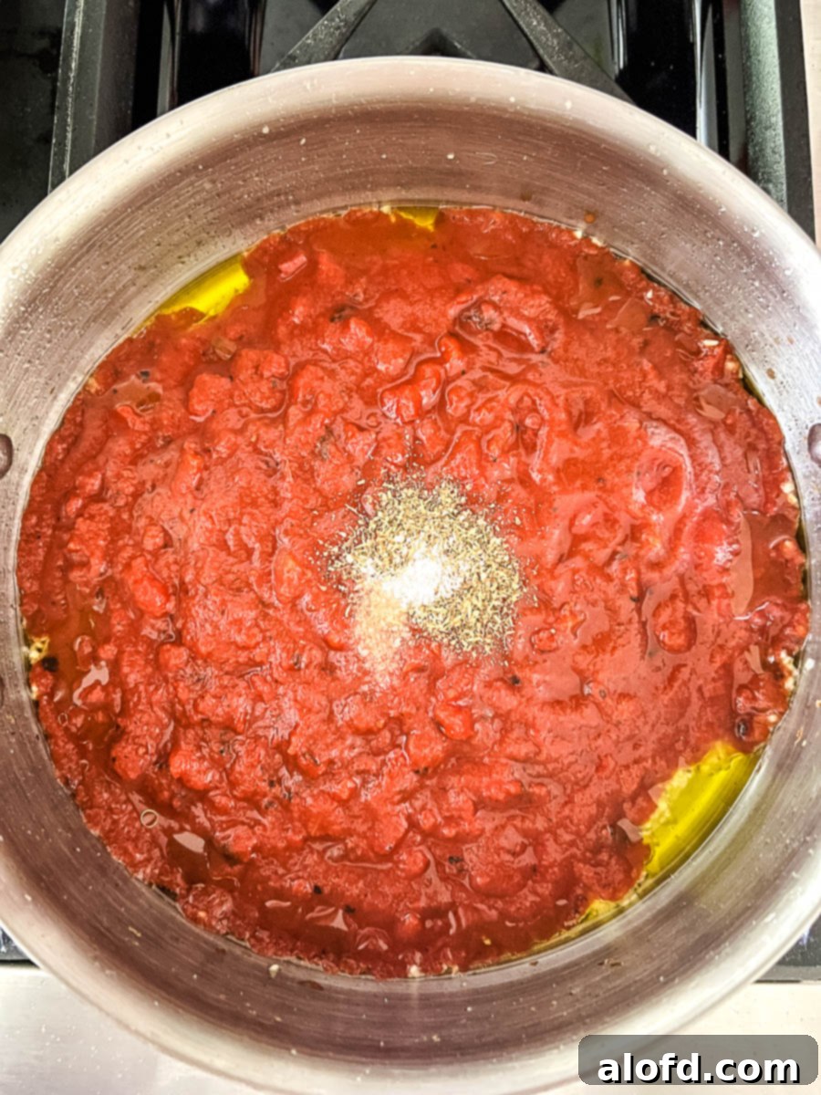 Making an easy Italian dinner of Penne alla Pomodoro in a skillet, showing the sauce simmering.