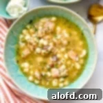 Big bowl of Instant Pot Pozole soup ready to be enjoyed, garnished with fresh cilantro and lime wedges.