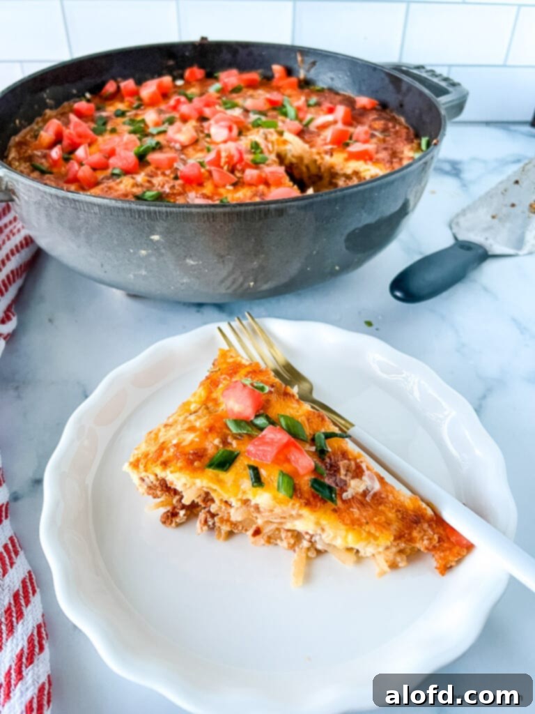 Cinco de Mayo breakfast of eggs with chorizo on a white plate with a fork. Round cast iron pot in the background, hinting at more delicious food.