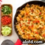 Walking taco casserole with Fritos in a skillet and dishes with toppings on the side, ready to be served for a fun family meal.