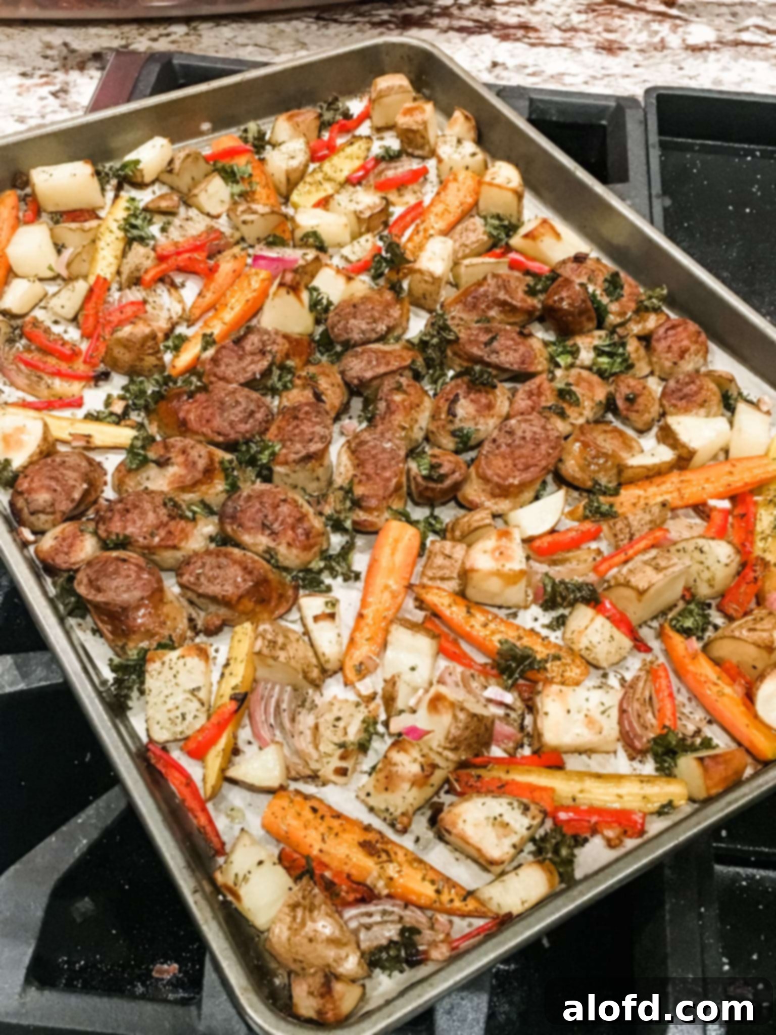 One-Pan Chicken Sausage and Roasted Vegetables 3 A close-up shot of roasted chicken sausage and a colorful array of vegetables on a sheet pan, showcasing their beautiful caramelization.