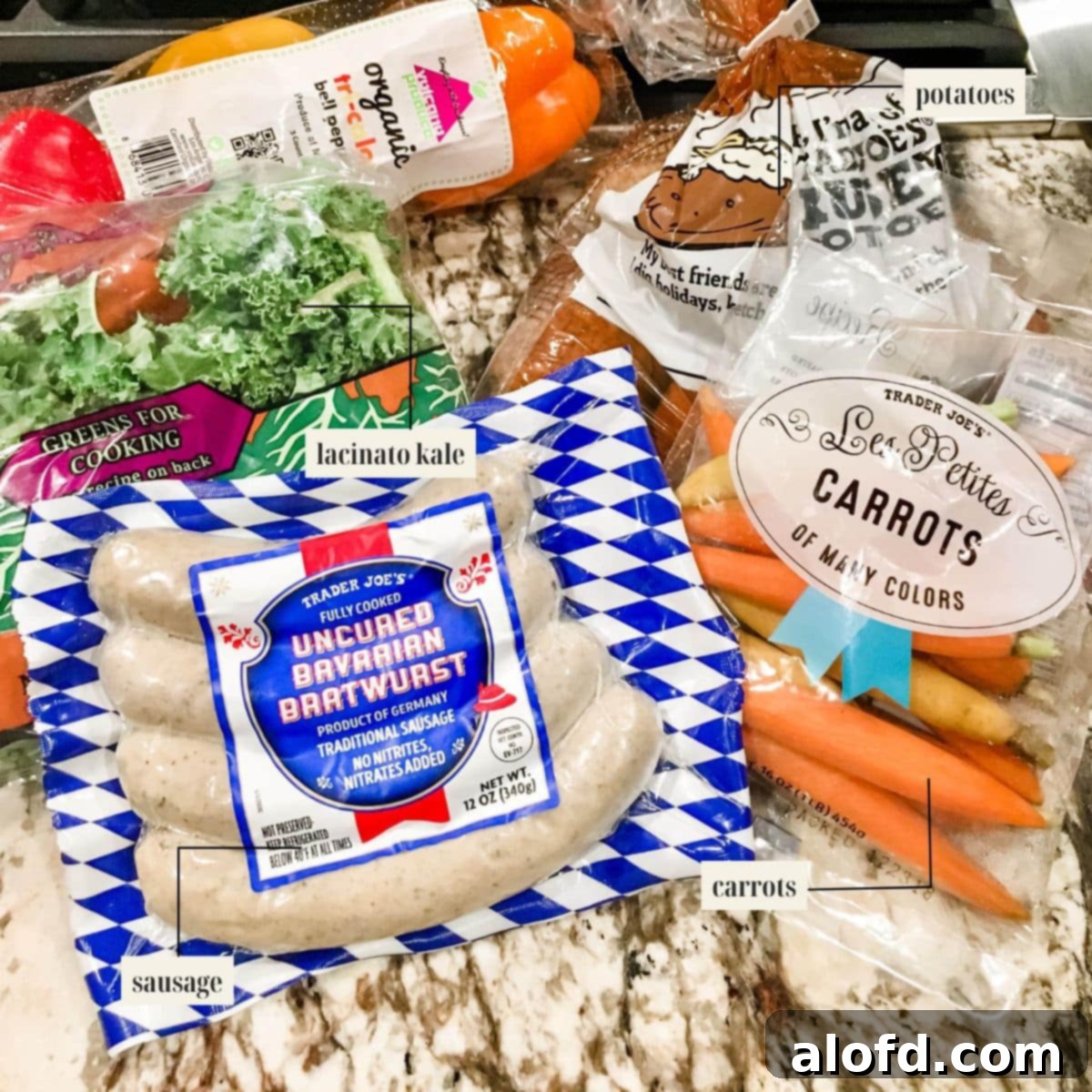 One-Pan Chicken Sausage and Roasted Vegetables 4 A carefully arranged spread of raw ingredients: sliced chicken sausage, cubed potatoes, carrots, red onion, and fresh kale, ready for the sheet pan.