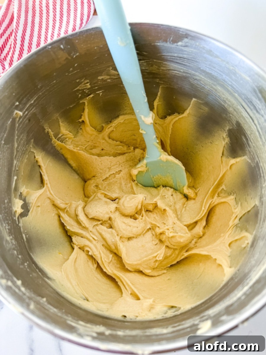 Mixing spatula in a mixing bowl with peach cobbler cake batter.