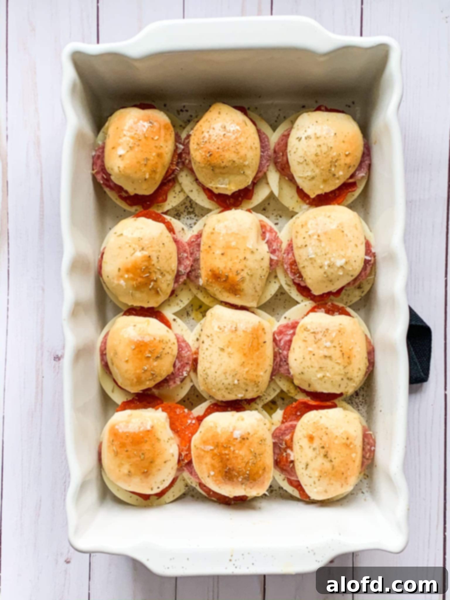 Zesty Italian Slider Bites 2 Baked Italian sliders in a white baking dish.