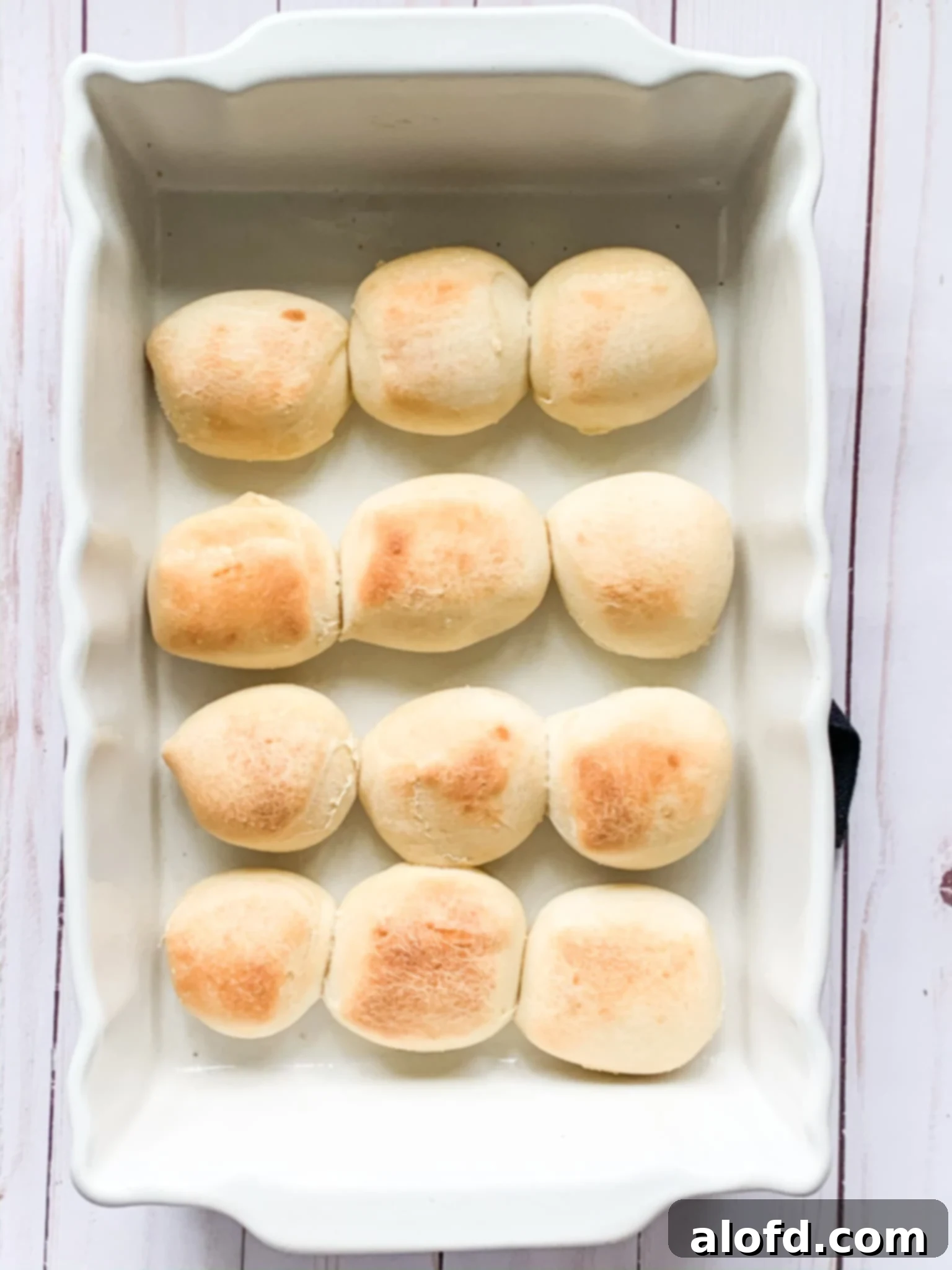 Zesty Italian Slider Bites 6 Baked Parker House rolls in a baking dish.