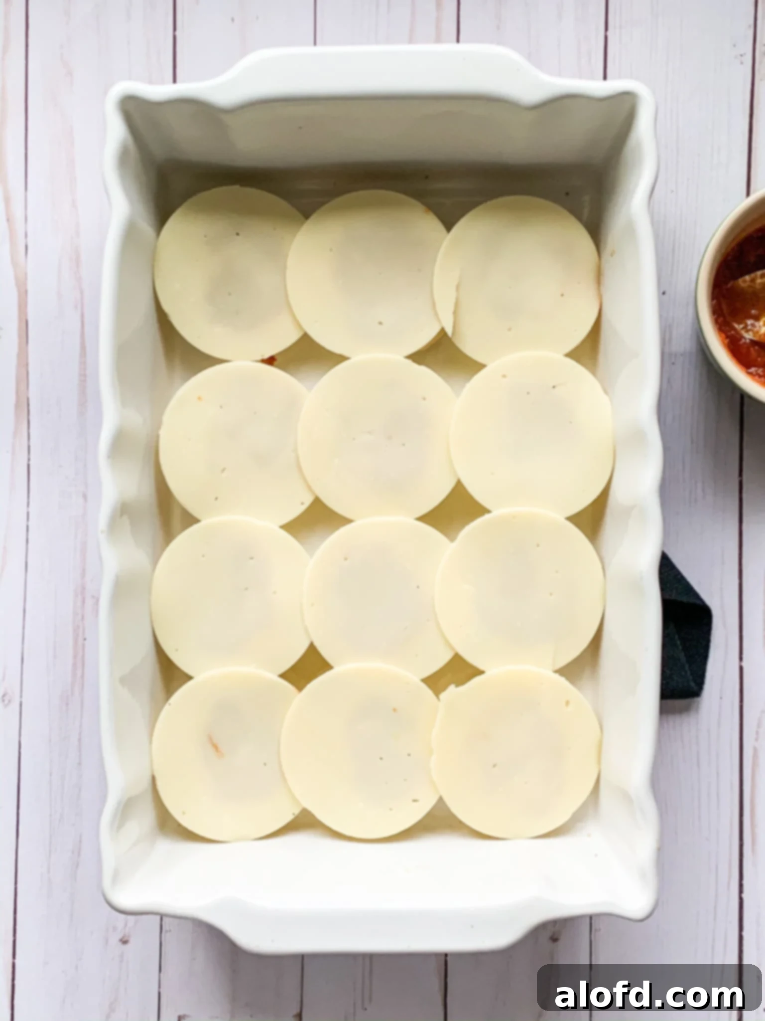 Zesty Italian Slider Bites 8 provolone cheese on top of game day sliders inside a baking dish.