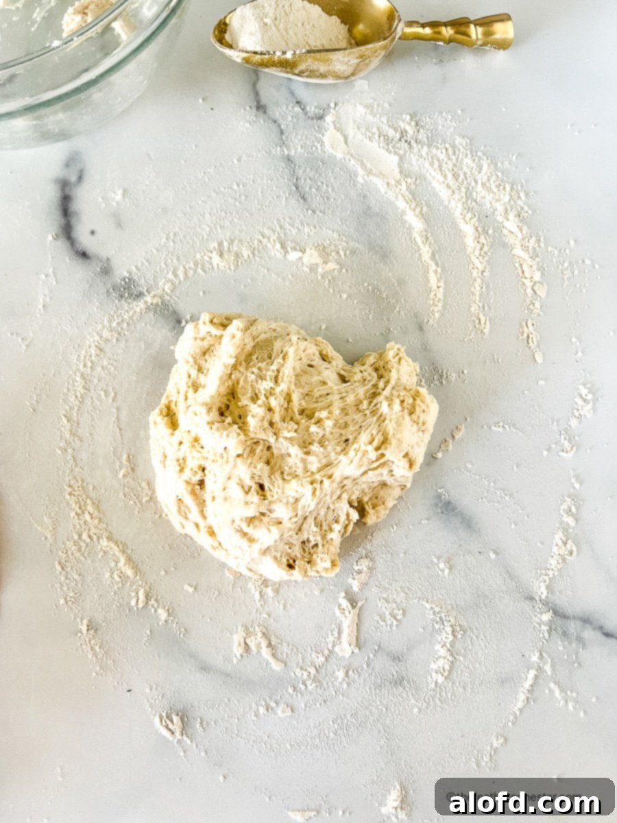 Foolproof Bisquick Pizza Dough 4 A smooth ball of no-yeast pizza dough resting on a lightly floured countertop, ready for the next step in the pizza-making process.