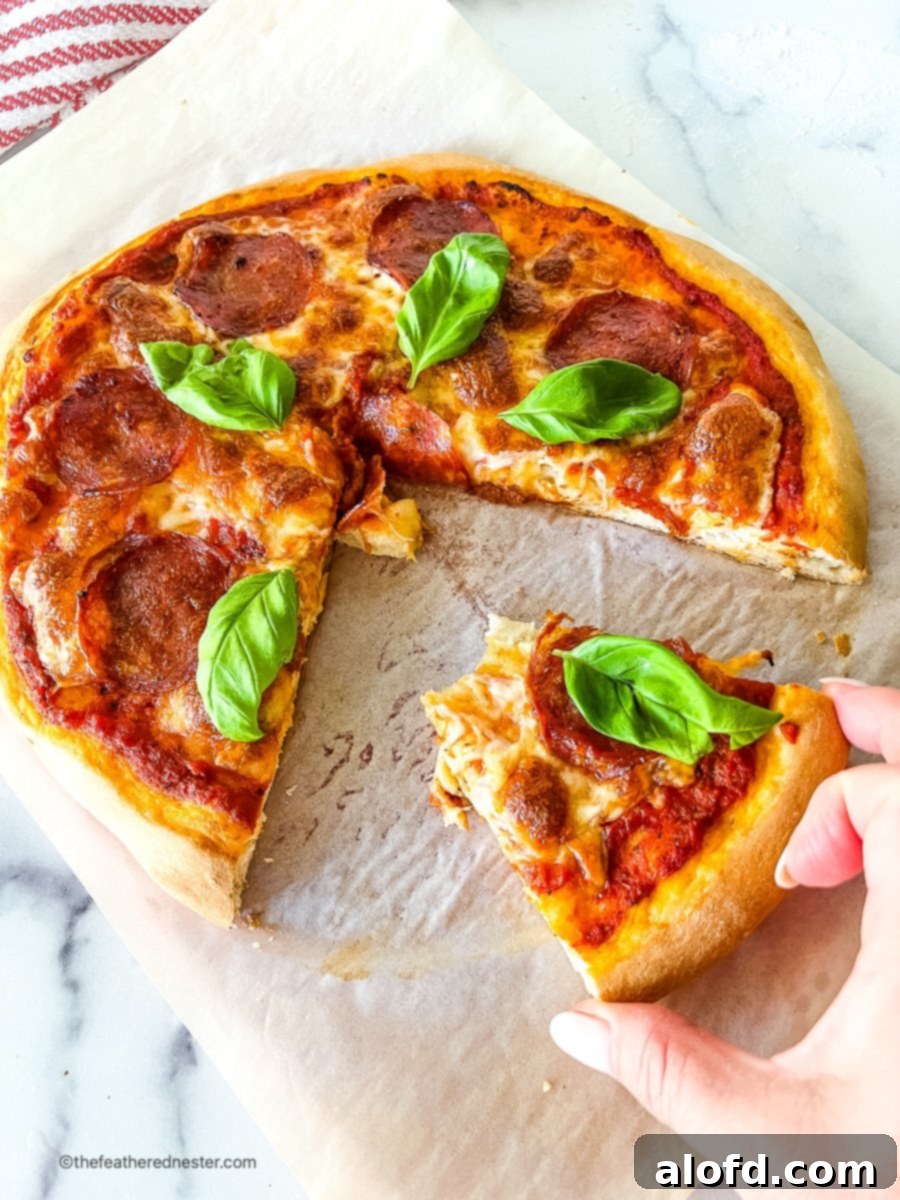 Foolproof Bisquick Pizza Dough 9 A woman's hand reaching for a slice of homemade pepperoni pizza, made with Bisquick pizza dough, showcasing its inviting golden crust.
