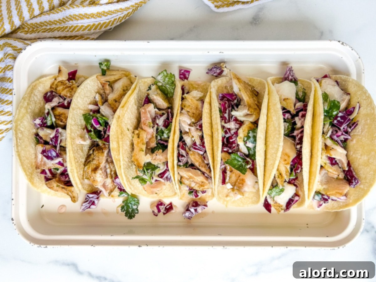 Platter of tacos topped with cucumber slaw.