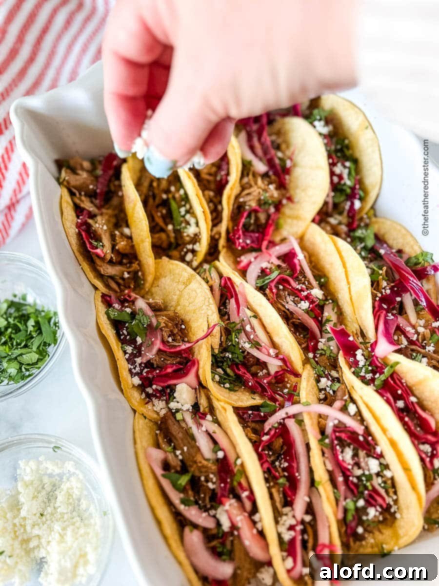Crumbling cotija cheese onto a platter of Mexican food.