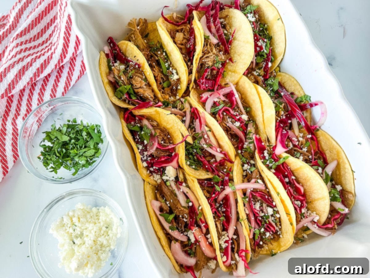 Platter full of Mexican street food next to small bowls with chopped cilantro and crumbled cheese.