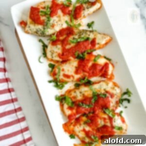 A platter brimming with perfectly baked Italian chicken cutlets, garnished with fresh basil.