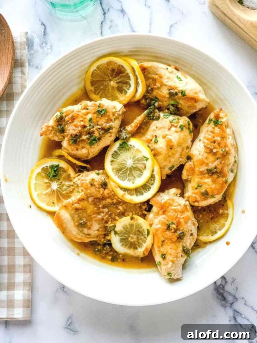 Chicken piccata Cheesecake Factory copycat meal, served on a round white platter with a side of pasta.