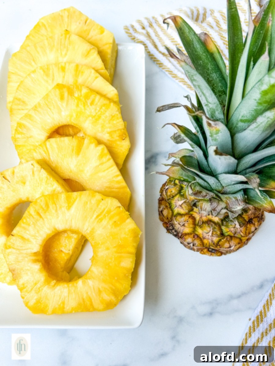 Fresh pineapple rings beautifully arranged on a white serving platter, ready to be enjoyed.