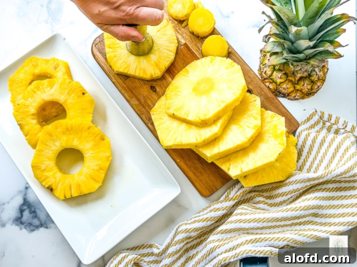 A woman using a pineapple corer to remove the core and create perfect pineapple rings.