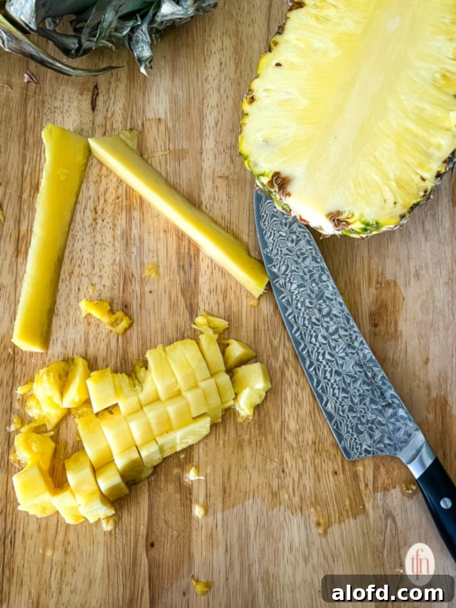 Chopped tropical fruit on a cutting board next to a large Shun chef's knife, illustrating post-coring preparation.